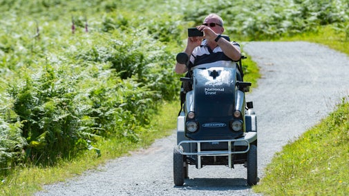 Visitor exploring a trail in an all-terrain mobility scooter